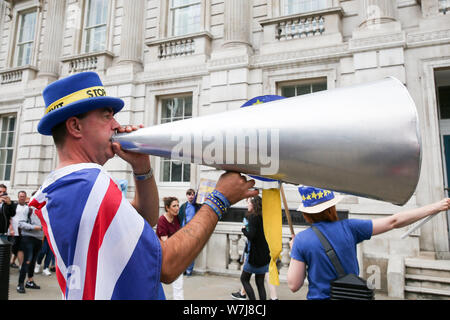 Pro-UE diruttori Steven Bray con un megafono mentre indossa una 'Stop Brexit' hat protestando al di fuori del Cabinet Office in Whitehall, Westminster, London. Foto Stock