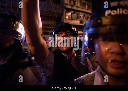 Un riot police officer grida a manifestanti e la pressa durante uno scontro.Migliaia di manifestanti hanno circondato il Sham Shui Po distretto stazione di polizia per chiedere il rilascio dello studente presidente dell unione Keith Fong Chung Yin che è stato arrestato per l'acquisto di una torcia-come puntatore laser che la polizia lo considerano come armi, stimolando gli ultimi scontri tra manifestanti e forze di polizia. Foto Stock