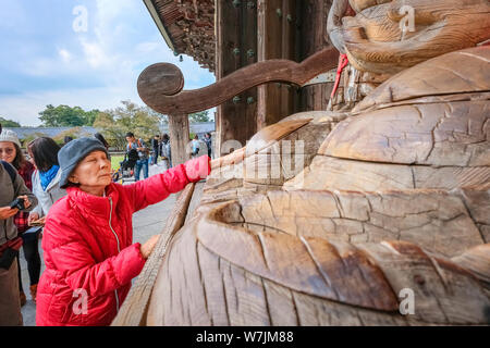 Nara, Giappone - 29 Ottobre 2018: Unidentified senior donna asiatica con Binzuru - la guarigione di Buddha a Tempio Todaiji Foto Stock