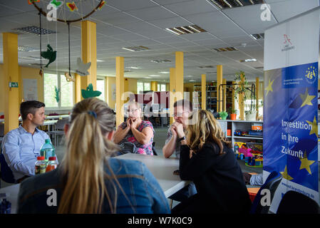 Oranienburg, Germania. 16 Luglio, 2019. Steffi Engels (terza da sinistra) e Ronny Kraemer, entrambi ex disoccupati di lunga durata, sedersi insieme con i caregivers e formatori del supporto di integrazione per disoccupati di lunga durata e la famiglia hanno bisogno di comunità. Tra il 2015 e il 2020, circa 40 milioni di euro dai fondi europei del programma sarà disponibile per il Brandeburgo. (A 'lontano dalla disoccupazione di lunga durata: lavoro nella cura o ufficio') Credito: Gregor Fischer/dpa/ZB/dpa/Alamy Live News Foto Stock