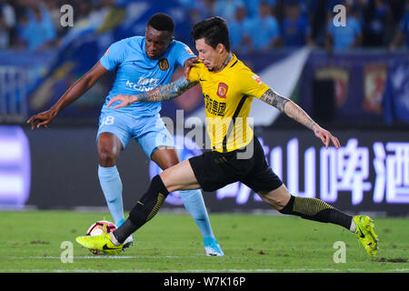 Camerunese giocatore di calcio Benjamin Moukandjo, sinistra, di Jiangsu Suning, sfide Zhang Linpeng di Guangzhou Evergrande Taobao nel loro 25 round m Foto Stock