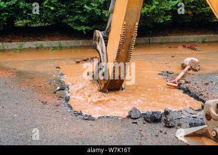 Riparare il tubo rotto per domestici di acqua sul terreno di fango. Foto Stock