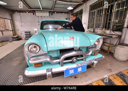 Il proprietario del 59-anno-vecchio 'Phoenix' auto d'epoca, pulisce la berlina dopo due mesi di lavori di ristrutturazione presso un garage in Cina a Shanghai, 28 settembre 2017. Foto Stock