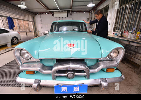 Il proprietario del 59-anno-vecchio 'Phoenix' auto d'epoca, pulisce la berlina dopo due mesi di lavori di ristrutturazione presso un garage in Cina a Shanghai, 28 settembre 2017. Foto Stock