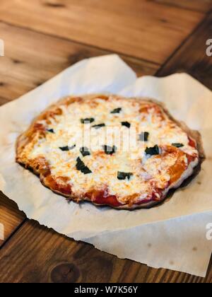 Pizza fatta in casa cibo tradizionale italiano impasto di grano integrale legno rustico sfondo Foto Stock