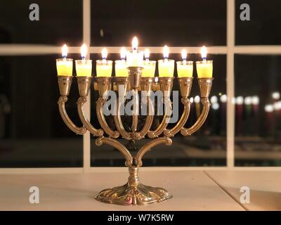 Hanukkah Menorah illuminazione delle candele festività ebraiche di simboli religiosi tradizionali luci nel buio Foto Stock