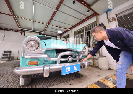 Il proprietario del 59-anno-vecchio 'Phoenix' auto d'epoca, pulisce la berlina dopo due mesi di lavori di ristrutturazione presso un garage in Cina a Shanghai, 28 settembre 2017. Foto Stock