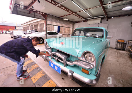 Il proprietario del 59-anno-vecchio 'Phoenix' auto d'epoca, pulisce la berlina dopo due mesi di lavori di ristrutturazione presso un garage in Cina a Shanghai, 28 settembre 2017. Foto Stock