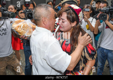 Il 33-anno-vecchio Genakuli Mahamat dal Xinjiang, abbracci la sua " padre " Li Zhongyi che ha aiutato il suo ritorno a casa dopo essere stata persa a Chengdu 21 anni fa Foto Stock