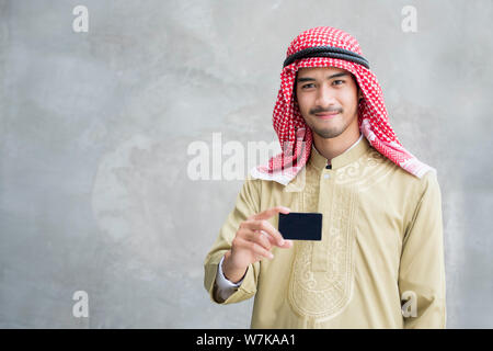 Sorridente bello arabian uomo azienda business card. Foto Stock