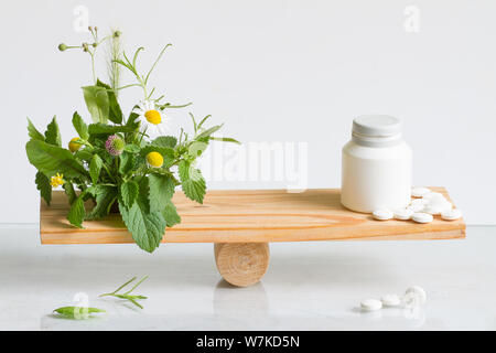Medicina alternativa o pillole di bilanciare il peso in confronto con le compresse e le erbe aromatiche Foto Stock