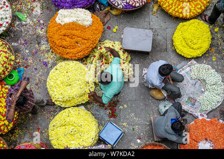 La gente la vendita di fiori freschi in commercio all'ingrosso all'interno di KR il mercato dei fiori in India che è uno dei più grandi mercati di fiori in Asia Foto Stock