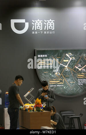 --FILE -- la gente visita lo stand del taxi-salutando e auto-service app Didi Chuxing durante il 2017 Global Mobile Internet Conferenza di Pechino, mento Foto Stock