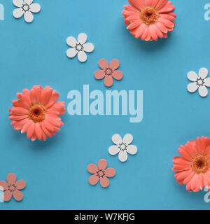 Coral gerbera daisy fiori e craft papper borse per lo shopping sul libro verde sullo sfondo, Primavera vendita Concetto di immagine con copy-spazio, compositio quadrato Foto Stock