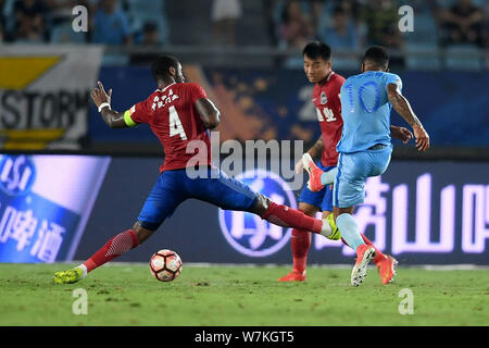 Il calcio danese player Edigeison Gomes, sinistra, di Henan Jianye calci la palla per effettuare un sorpasso ai danni di un giocatore di Jiangsu Suning nel loro ventesimo turno mat Foto Stock