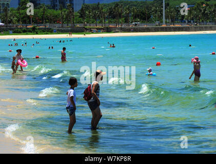 I turisti hanno divertimento nell'acqua inquinata con alghe blu-verde fiore a un beach resort nella città di Sanya, Cina del sud della provincia di Hainan, 21 agosto 2017. Foto Stock