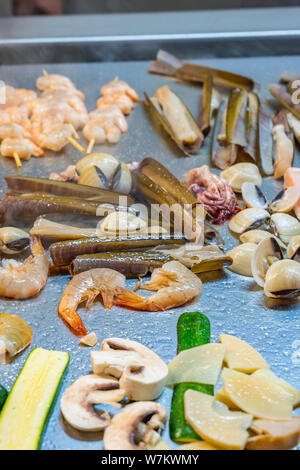 Foto verticale di un assortimento di piatti di pesce alla griglia su piatto di pesata in acciaio inox Foto Stock