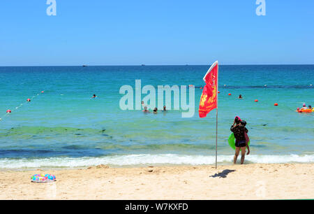 I turisti hanno divertimento nell'acqua inquinata con alghe blu-verde fiore a un beach resort nella città di Sanya, Cina del sud della provincia di Hainan, 21 agosto 2017. Foto Stock