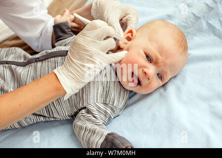 Infermiere orecchio pulizia del neonato Foto Stock