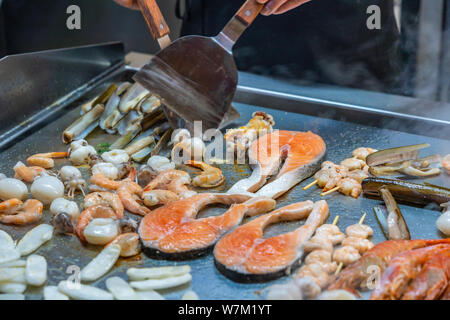 Molti tipi di frutti di mare cotti sul tavolo grill al ristorante Foto Stock