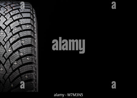 Nuovo inverno pneumatici chiodati, di sicurezza e di qualità premium. sfondo nero, close-up Foto Stock