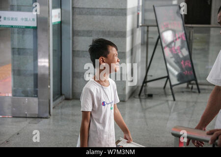 Sulla sinistra di un bambino dietro le lacrime dopo la separazione con sua madre a Quanzhou Stazione Ferroviaria di Quanzhou city, a sud-est della Cina di provincia del Fujian, 25 agosto Foto Stock