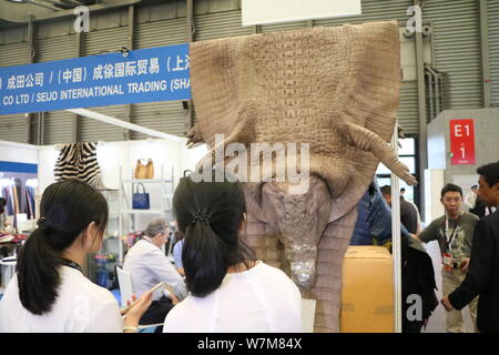 Visitatori guardare tutta una pelle di coccodrillo visualizzato presso lo stand di Narita Co Ltd,/ Seijo International Trading (Shanghai) Co Ltd., durante tutto il mento Foto Stock