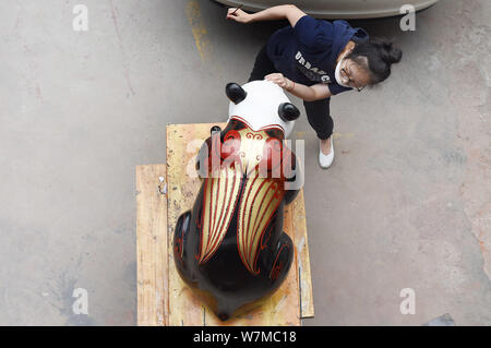 --FILE--un artista cinese dipinge una delle due dimensioni reali laccati panda giganti di Chengdu, a sud-ovest della Cina di provincia di Sichuan, 16 giugno 2017. Foto Stock