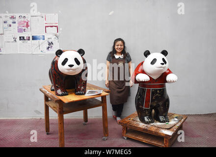 --FILE--un artista cinese è raffigurato con due life-size laccati panda giganti di Chengdu, a sud-ovest della Cina di provincia di Sichuan, 16 giugno 2017 Foto Stock