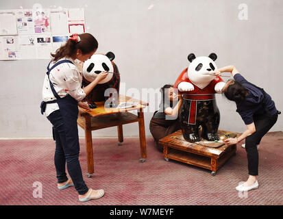 --FILE--artisti cinesi verniciatura di una delle due dimensioni reali laccati panda giganti di Chengdu, a sud-ovest della Cina di provincia di Sichuan, 16 giugno 2017. C Foto Stock