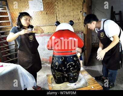 --FILE--artisti cinesi verniciatura di una delle due dimensioni reali laccati panda giganti di Chengdu, a sud-ovest della Cina di provincia di Sichuan, 16 giugno 2017. C Foto Stock