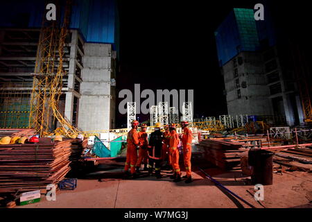 I soccorritori cinese di tentare di salvare i lavoratori sono bloccati in posizione da lui Deforma struttura in acciaio di un crollato gru a torre in un cantiere in Haizhu dist Foto Stock