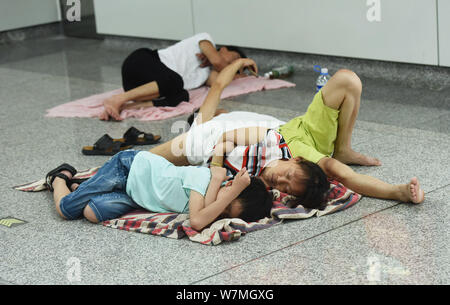 La gente di riposo in un'aria condizionata la stazione della metropolitana di sfuggire al caldo su un bruciante giorno nella città di Hangzhou, a est della Cina di provincia dello Zhejiang, 22 luglio 2017. Foto Stock