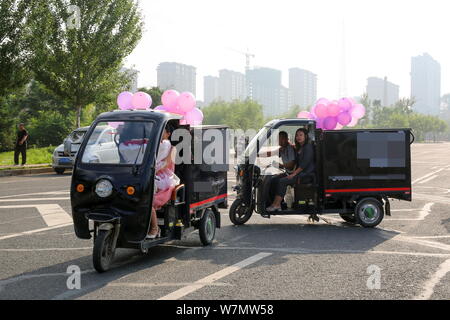 Un totale di 11 cinesi i veicoli di consegna in coda fino a formare un per il giro della Papamobile per un corriere come egli si prepara a proporre alla sua ragazza che egli conosce la th Foto Stock