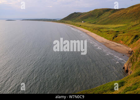 Panoramica di Rhossili Bay a marea alta con onde che lambiscono la spiaggia sabbiosa di seguito Rhossili giù, la Penisola di Gower, Wales, Regno Unito, Luglio. La sequenza 2 di 2 vista di adattamento con differenti maree Foto Stock