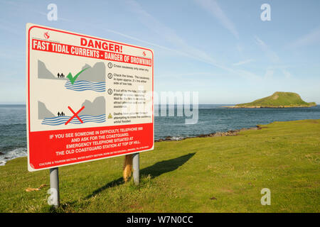 Segno di avvertimento quando si è insicuri per attraversare una strada rialzata di marea, con la vite senza fine la testa tagliata fuori dal continente come un isola ad alta marea, Rhossili, La Penisola di Gower, Wales, Regno Unito, Luglio. La sequenza 2 di 2 vista di adattamento con differenti maree Foto Stock