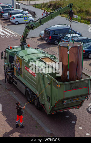 Egmond aan Zee, Paesi Bassi - 24 Giugno 2019: un garbage collector solleva un enorme sacchetto di rifiuti in un camion della spazzatura utilizzando una gru da camion Foto Stock