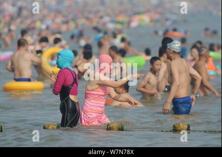 I turisti che indossa facekinis sono illustrati in una spiaggia durante il periodo più caldo dell'anno - sanfu nella città di Qingdao, Cina orientale della provincia di Shandong, 12 J Foto Stock