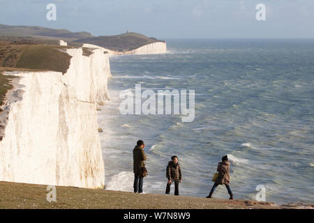 La gente che prende le immagini di fronte a sette sorelle chalk scogliere con mare mosso. South Downs, Inghilterra, novembre 2011. Foto Stock