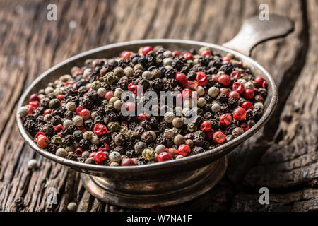 Grani di pepe misto rosso nero e bianco nella ciotola - Close-up Foto Stock