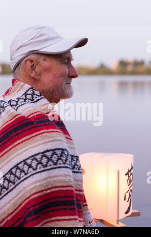 Un uomo detiene un lanterne di carta al Toro Nagashi Lanterna cerimonia flottante in Seattle, Washington il 6 agosto 2019. "Da Hiroshima alla Speranza" è tenuto in ricordo della bomba atomica vittime per l Anniversario del bombardamento di Hiroshima, Giappone. La cerimonia, organizzata da una collazione di pace, religiosi, delle libertà civili e il patrimonio culturale delle organizzazioni, onora le vittime dei bombardamenti di Hiroshima e Nagasaki, e tutte le vittime della violenza. Si tratta di un adattamento di un antico Buddista Giapponese rituale, il Toro Nagashi, in cui lanterne che rappresentano le anime dei morti sono negoziate in mare e Foto Stock