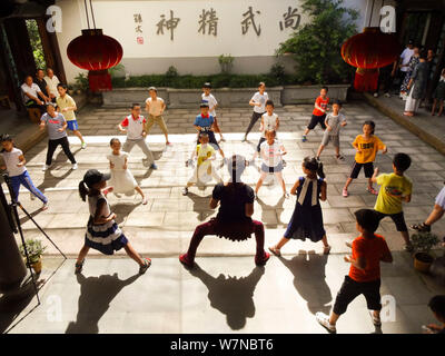 I figli di lavoratori migranti pratica ''Wenzhou Nanquan'', una singolare arte marziale del Sud Arti marziali cinesi, sotto un pullman la guida di Dell a Wenzh Foto Stock