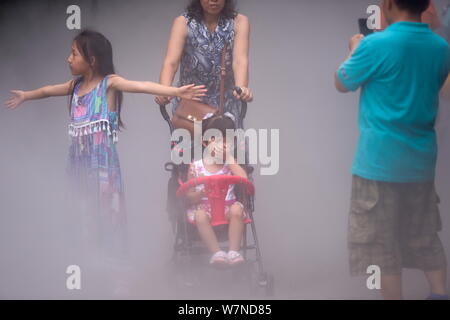 Un turista si copre la bocca e il naso con le sue mani come ella gli errori il vapore acqueo per il denso fumo di un incendio presso lo Zoo di Beijing in Cina, 25 Foto Stock