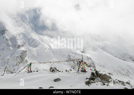 La preghiera buddista bandiere ad alta altitudine nel Larkya La (5.106m) nella neve, Il Manaslu Area di Conservazione, Himalaya, Nepal, ottobre 2009. Foto Stock