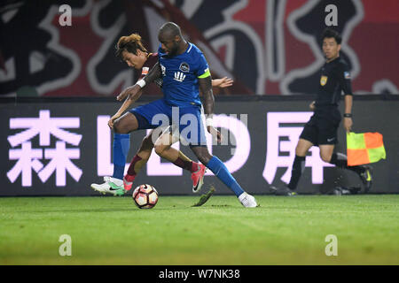 Il calcio danese player Edigeison Gomes, destro di Henan Jianye calci la palla per effettuare un sorpasso ai danni di un giocatore di Hebei Cina Fortune nel loro xvi rou Foto Stock