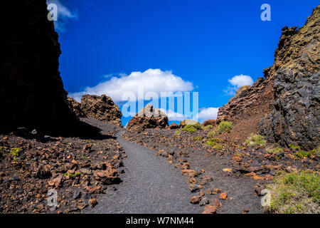 Spagna Lanzarote, popolare el cuervo cratere del vulcano Sentiero escursionistico attraverso colorate di roccia vulcanica e del paesaggio Foto Stock