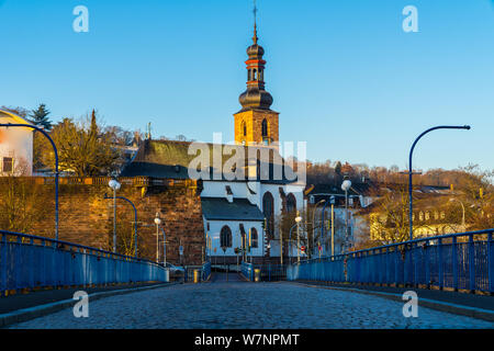 Germania, antica e famosa chiesa schlosskirche dietro il ponte blu di saarbruecken città vecchia nella calda luce del mattino Foto Stock