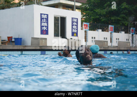 Gli studenti africani si divertono a rinfrescarvi in piscina in un bruciante giorno nella città di Fuzhou, a sud-est della Cina di provincia del Fujian, 23 luglio 2017. Foto Stock