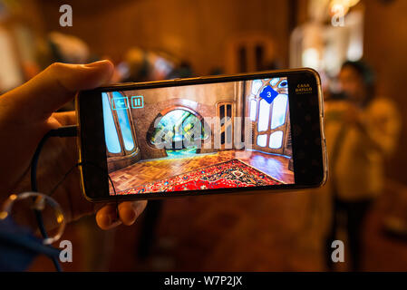 Vista di conformata a fungo camino visto attraverso augmented reality tour telefono di Casa Batllo progettato da Antoni Gaudi, Barcellona, Spagna Foto Stock