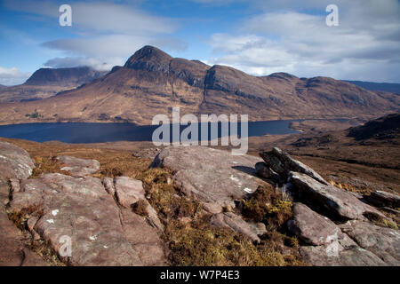 Vista sul Loch Lurgainn a Cul Beag e Cul Mor, con rocce in primo piano, Ben Mor Coigach Scottish Wildlife Trust Reserve, Coigach, Scozia, marzo 2012. Foto Stock